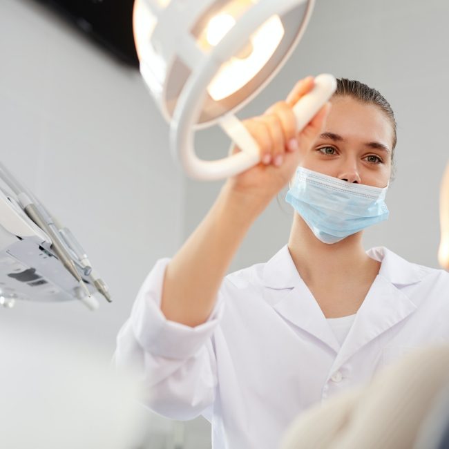 female-dentist-adjusting-lamp.jpg